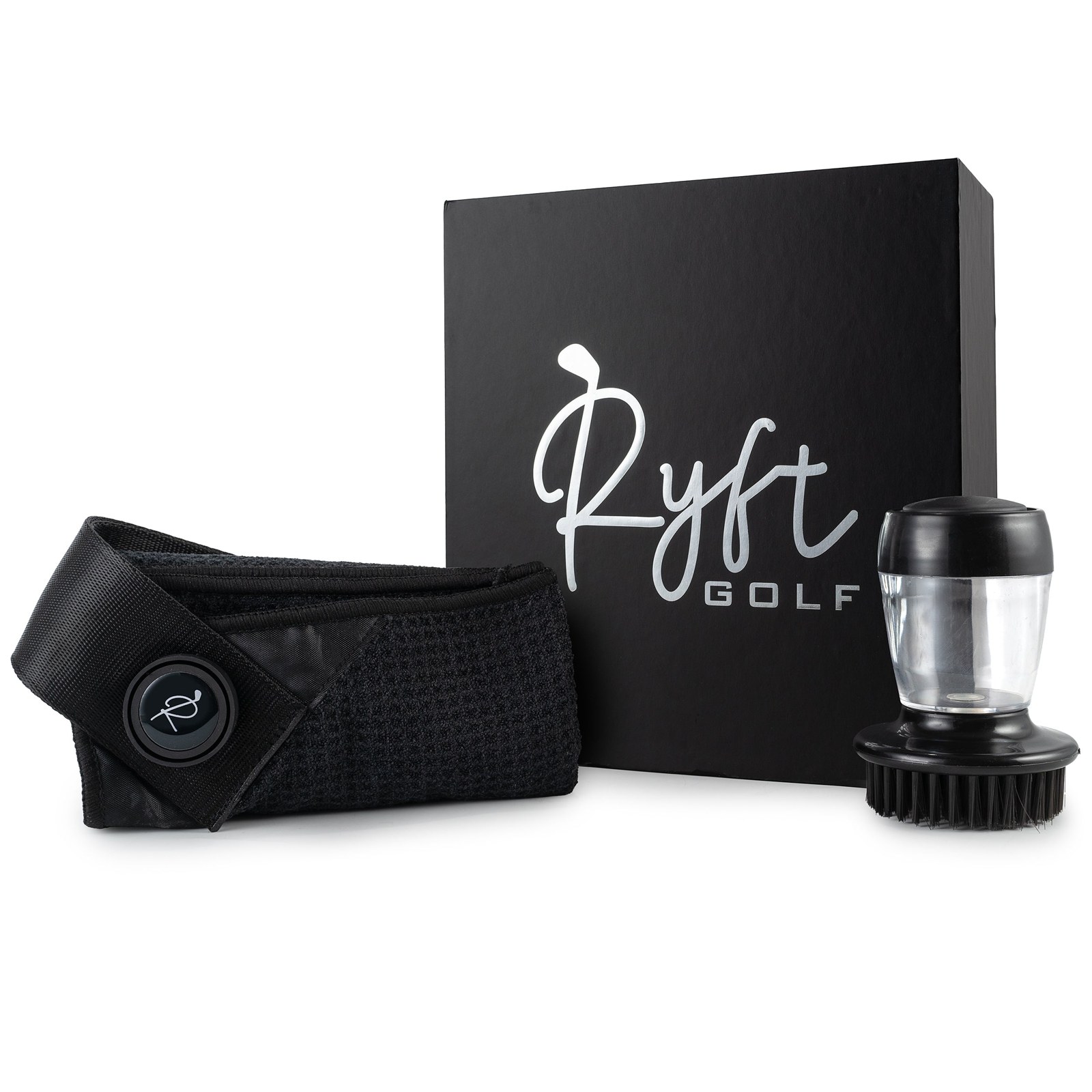 A folded black waffle-weave Ryft golf towel with its magnetic strap and logo disc, next to the round brush tool with a clear refillable water reservoir, in front of a matte black Ryft Golf gift box